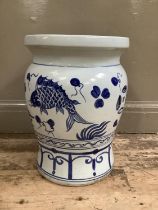 A Chinese blue and white garden seat of baluster form, painted with fish above an ornate border,