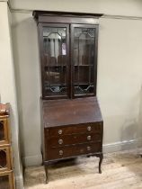 A 20th century mahogany bureau bookcase with two glazed doors above drop leaf, the interior fitted