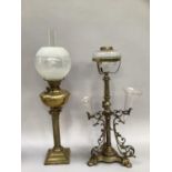 A Victorian brass mounted oil lamp having a lobed reservoir upon turned column with three lower