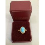 A single stone turquoise dress ring in 9ct gold, the oval cabochon stone collet set within a twisted