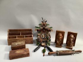 Carved cuckoo clock, a pair of carved indigenous book ends, two carved boxes inlaid with mother of