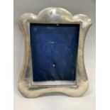 A silver photograph frame Birmingham 1906 of shield shape and planished frame finish, 24.5cm x 29.