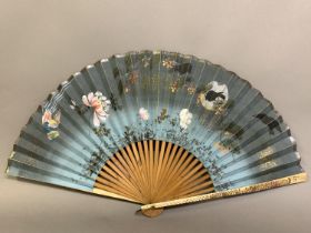 A Japanese fan with painted bone guards, inset with mother of pearl flowers and a butterfly, and