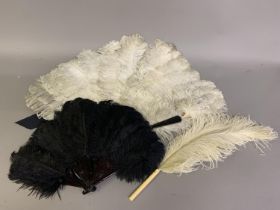 A large white ostrich feather fan, the monture of tortoiseshell, fitted with a wide black satin