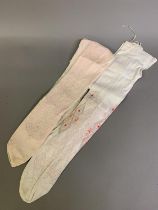 A pair of 19th century cotton stockings featuring wide drawn thread and pink and pastel embroidery