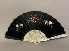 A later 19th century pink mother of pearl fan, the monture pierced and delicately etched, the leaf