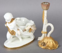 A MOORE BROS WHITE GLAZED FIGURE OF A CHERUB pulling a shell-form basket with turquoise ropes and