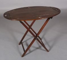 AN OAK AND BRASS BUTLER'S TRAY, oval hinged sides with finger grips, on a folding stand, c.1920s,