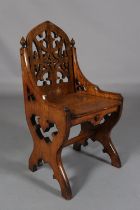 A 19TH CENTURY GOTHIC REVIVAL OAK CHAIR, having a lancet shaped back of pierced tracery, the arms