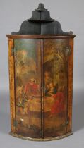 A GEORGE III HANGING CORNER CABINET, the bow front doors painted with a continental scene of saintly