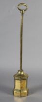A 19TH CENTURY BRASS DOOR PORTER of angled form with loop handle, 55cm high
