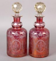 A PAIR OF RUBY AND CLEAR GLASS DECANTERS, cylindrical, etched with flower filled cartouche and