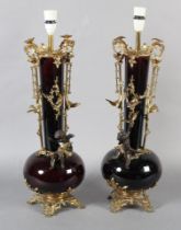 A PAIR OF FRENCH DEEP PURPLE GLASS AND GILT METAL MOUNTED LAMPS, the elongated neck with twin