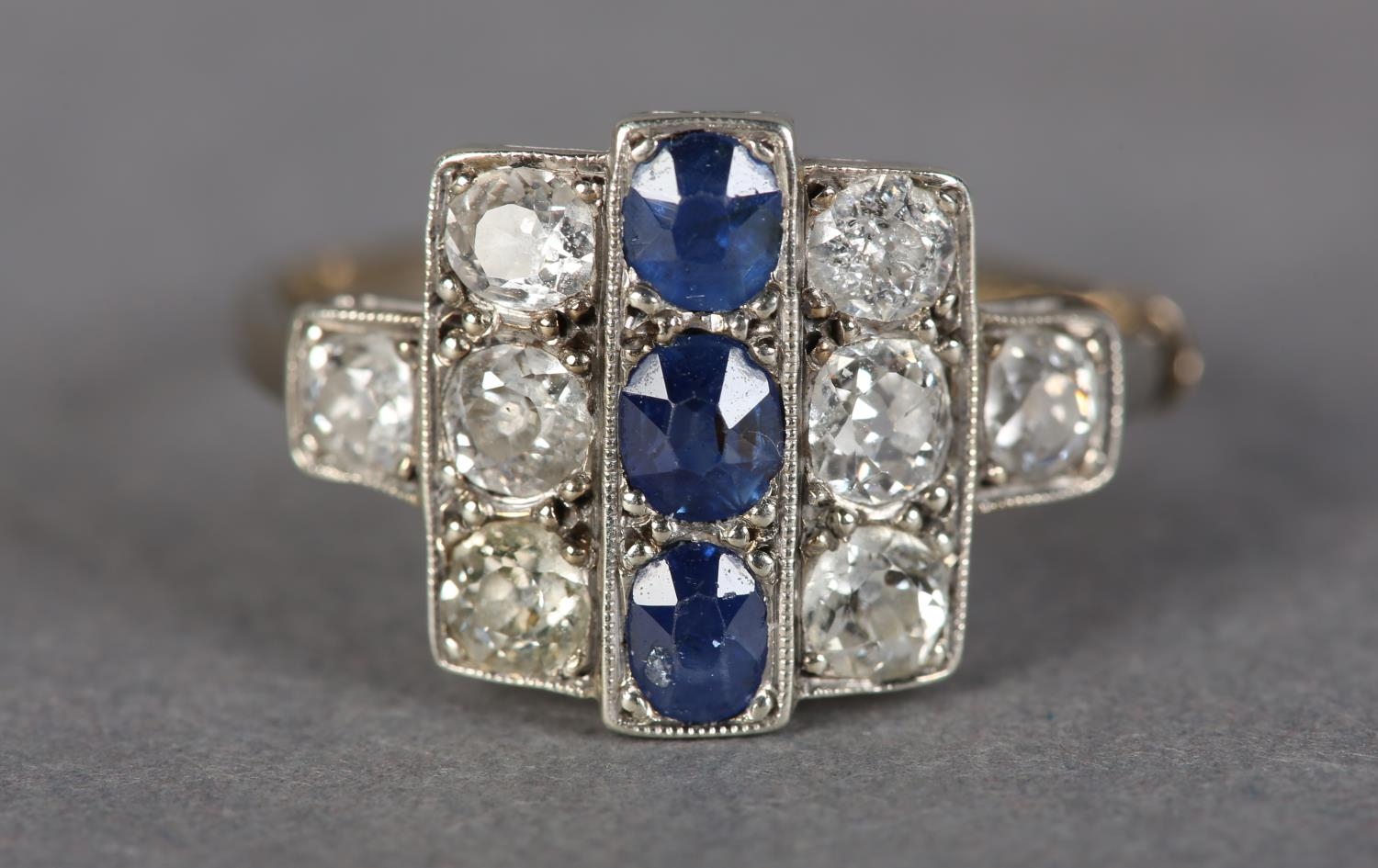 AN ART DECO SAPPHIRE AND DIAMOND CLUSTER RING in platinum set to the centre with three oval