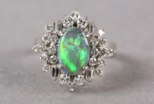 A BLACK OPAL AND DIAMOND CLUSTER RING, the oval cabochon opal claw set and raised against a tiered