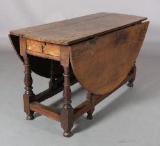 AN 18TH CENTURY OAK GATELEG DINING TABLE having twin oval drop leaves, drawer to the apron, on