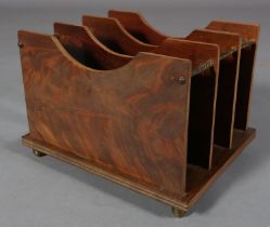 AN ART DECO FIGURED MAHOGANY MAGAZINE RACK, of three panelled divisions with gilt metal rails and