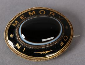 A VICTORIAN MOURNING BROOCH set with black enamel and banded agate in 9ct gold, the oval cabochon