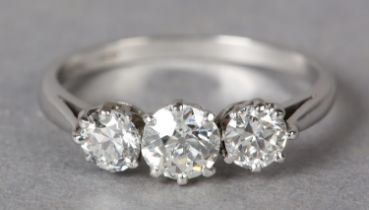 A THREE STONE DIAMOND RING c1950 in platinum, the graduated transitional brilliant cut stones claw