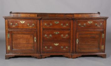 AN 18TH CENTURY OAK INVERTED BREAKFRONT DRESSER BASE, the short raised back fitted with three