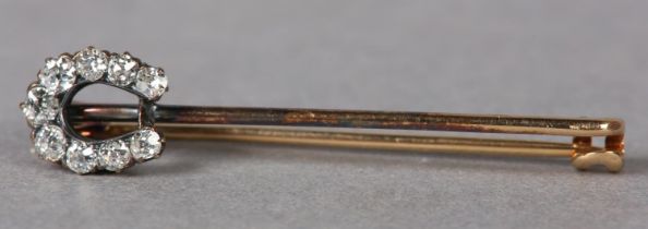 AN EDWARD VII DIAMOND SET HORSE SHOE STICK PIN in 15ct gold, the Old European cut stones claw set