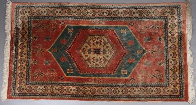 A CAUCASIAN SILK CARPET, the coral field having a turquoise and coral medallion with geometric