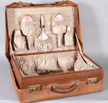 A BROWN LEATHER COVERED DRESSING CASE fitted with a pink guilloche enamelled and silver hand mirror,