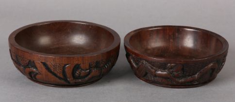 A PAIR OF LIGNUM VITAE BOWLS, circular, carved to the exterior with opposing tribesmen brandishing