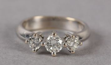 A THREE STONE DIAMOND RING, the graduated brilliant cut stones each in a four claw setting in a