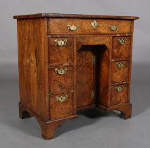 A QUEEN ANNE FIGURED WALNUT KNEEHOLE DESK, the top quarter-veneered and crossbanded above a drawer