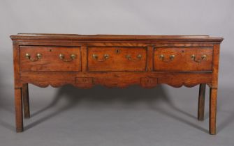 A LATE 18TH/EARLY 19TH CENTURY OAK DRESSER BASE having a short raised back, the trapezoid shaped top
