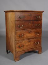 AN EARLY 19TH CENTURY OAK CHEST of four graduated drawers, brass escutcheons and swing handles, on