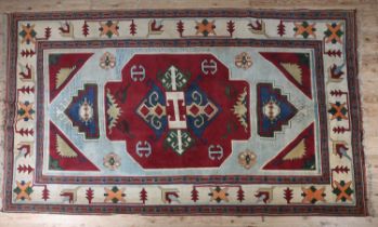 A KAZAK CARPET, the pale blue ground having a maroon panel and spandrels filled with geometric
