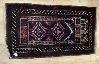 A small middle Eastern rug of dark blue and red ground, prayer niche with two diamond medallions,