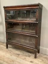 An oak and glazed sectional bookcase in the style of Globe Wernicke having three tiers, on short