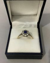 A sapphire and diamond cluster ring c1950 in 18ct gold and platinum, claw set to the centre with