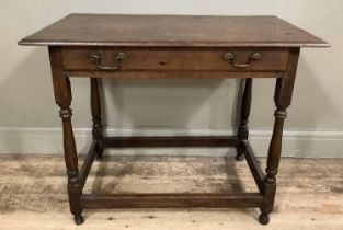 A 19th century oak side table with drawer to the apron, brass swing handles and on turned and square