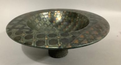 An ceramic dish on a deep foot with wide rim, with metallic glaze, having geometric shapes in