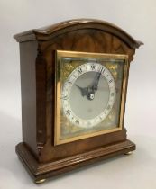 An Elliott mantle clock with silvered and gilt dial, in walnut case on brass bun feet, 18cm high