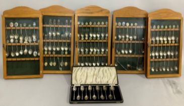 A quantity of souvenir spoons from the British Isles in five glazed oak cases