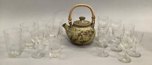 A studio pottery teapot with brown texture over pale green ground, with bamboo handle marked NN to