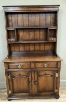 A Titchmarsh and Goodwin oak dresser having a moulded rack above a planked back with shelves, open