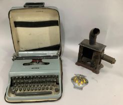 A tin plate magic lantern with lens, an AA car badge and an Olivetti vintage typewriter in carry