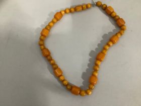 An early 20th century bakelite necklace, the cylindrical beads of two sizes (approximately 15mm x