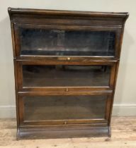 An oak and glazed sectional bookcase in the style of Globe Wernicke, three tiers, on curved plinth