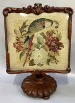 A 19th century carved mahogany pole screen having a needlework panel of a parrot (reduced and A/F)