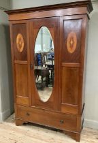 An Edwardian mahogany and satin wood inlaid wardrobe with single mirrored door and drawer below,