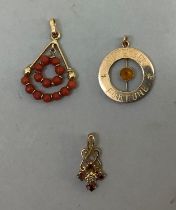 Two pendants both in 9ct gold variously set with rubies, a small eight cut diamond and coral