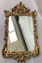 An 18th century style gilt mirror in a pierced, foliate and C-scroll frame with rectangular plate,