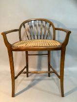 A stained beech and begere caned low back chair on turned and square framing